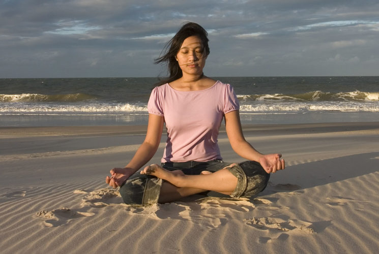 Picture of a lady sitting on a beach.