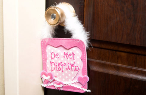 Pink Do Not Disturb Sign hanging from bedroom door